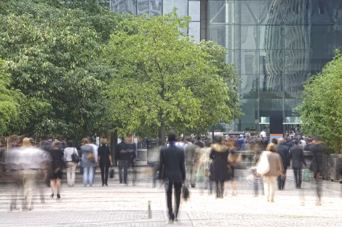 Image floue de personnes marchant sur une place dans un quartier d'affaires